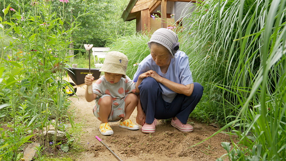 정영선 조경가가 손자와 함께 식물을 돌보는 모습. 다큐멘터리 영화 '땅에 쓰는 시'에 소개됐다.