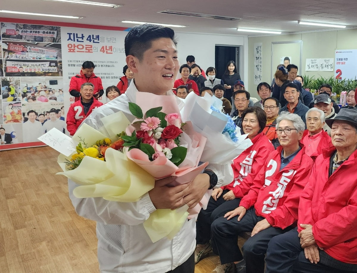 김재섭 국민의힘 서울 도봉구 갑 후보가 11일 선거사무소에서 당선된 후 꽃다발을 받고 있다. 뉴스1