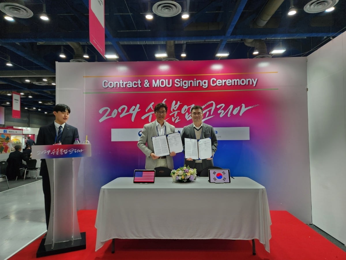 오재환 인투시 대표(오른쪽)가 지난 15일 서울 코엑스에서 열린 수출붐업 코리아 수출상담회에서 미국 코스트코 홀세일 코퍼레이션 관계자와 협약서를 들고 기념촬영을 하고 있다. 인투시 제공 