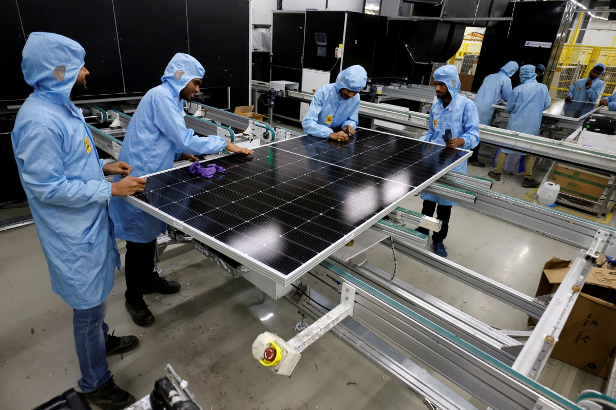인도 구자라트주 문드라에 있는 아다니 그린 에너지(AGEL) 공장에서 지난 11일 노동자들이 태양광 모듈을 조립하고 있다. /로이터
