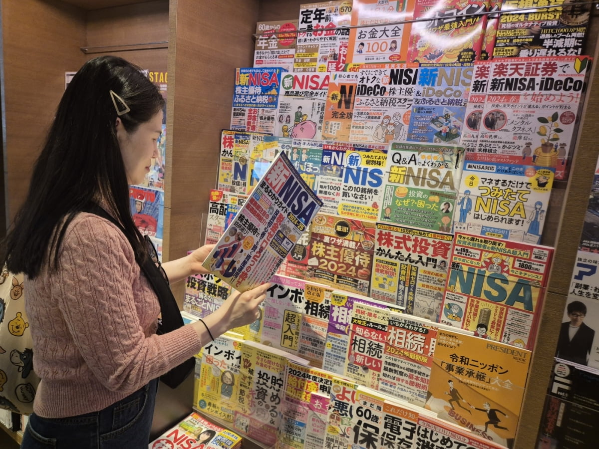 지난 14일 일본 도쿄 시부야구 다이칸야마에 있는 쓰타야 서점에서 한 시민이 ‘신(新)소액투자비과세제도(NISA)’에 대한 책을 읽고 있다. 