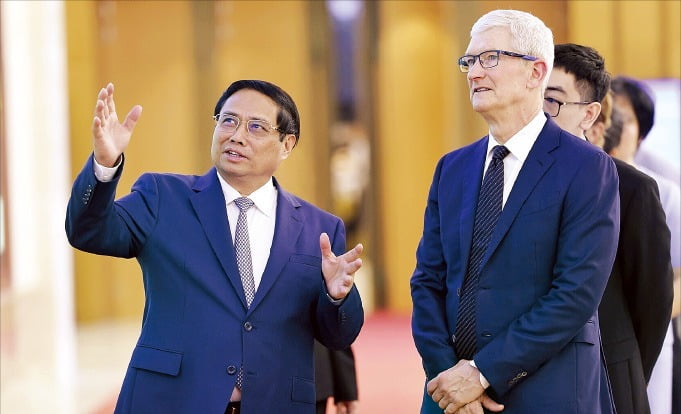 < 팜민찐 총리·팀 쿡 ‘화기애애’ >  베트남을 방문 중인 팀 쿡 애플 최고경영자(CEO·오른쪽)가 16일 하노이 정부청사에서 팜민찐 베트남 총리와 이야기를 나누고 있다. 중국 공급망 의존도를 낮추는 방안을 모색하고 있는 쿡 CEO는 이날 베트남 공급망에 대한 투자 확대 계획을 밝혔다.  AP연합뉴스 