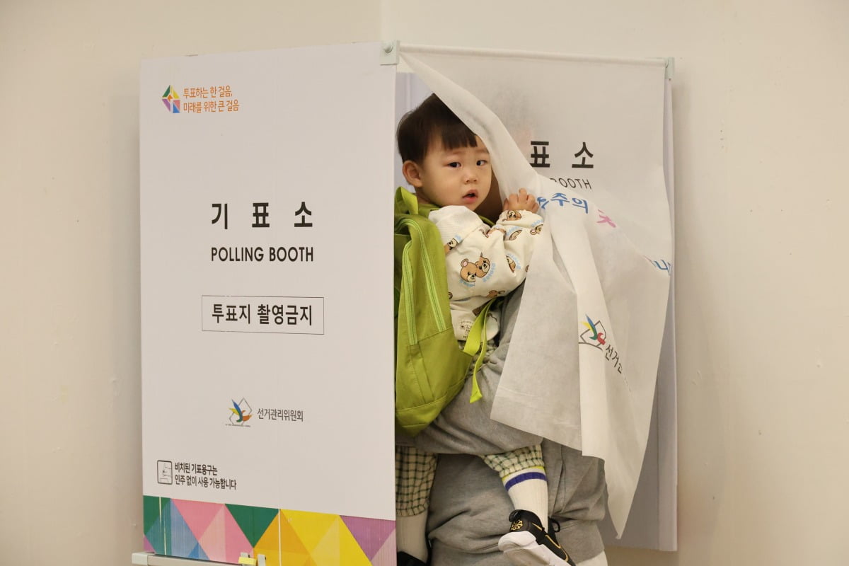  제22대 총선 사전투표일이 시작된 5일 오전 대전시 서구 둔산동 대전시청에 마련된 사전투표장에서 유권자가 어린 자녀를 안고 투표하고 있다. 연합뉴스