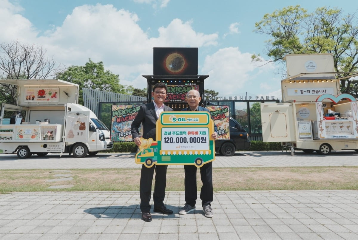 안종범 에쓰오일 마케팅총괄 사장(왼쪽)과 이세중 함께일하는재단 이사장(오른쪽)이 8일 서울 마포구 망원한강공원에서 열린 ‘청년 푸드트럭 유류비 전달식’에서 기념 촬영을 하고 있다. 에쓰오일 제공