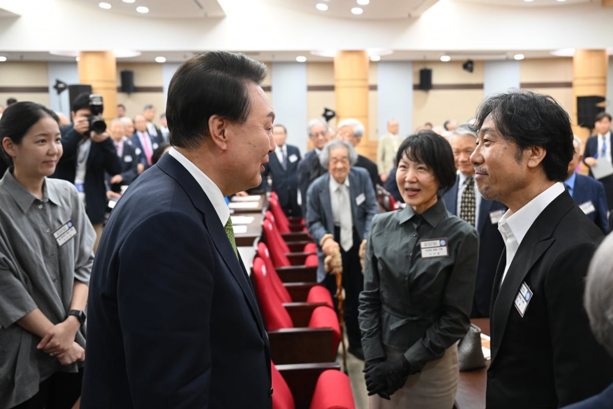 윤석열 대통령이 22일 서울 서초구 대한민국학술원에서 열린 개원 70주년 기념식에서 국민훈장 무궁화장을 수상한 이상만 회원의 딸과 사위인 가수 이문세와 인사하고 있다. /사진=대통령실 제공