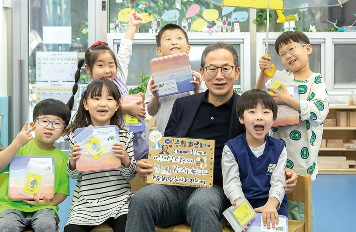 양 회장이 지난 5월 3일 KB여의도직장어린이집을 찾아 어린이들에게 선물을 건네고 함께 기념촬영을 하고 있다. 한국경제