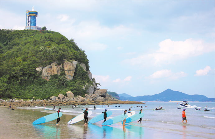 고흥 남열해돋이해수욕장에서 서핑객들이 바다로 걸어가고 있다.  /전라남도 제공
 