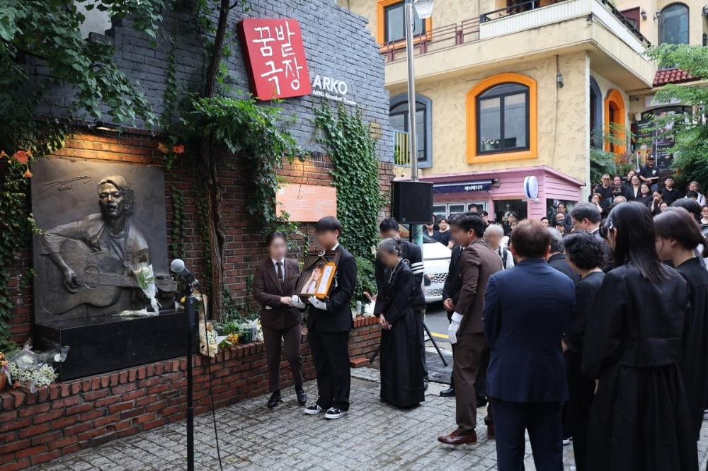 서울 대학로 소극장의 상징 '학전'을 30여년간 운영하며 후배 예술인을 배출해 온 가수 김민기의 발인식이 엄수된 24일 오전 고인의 영정이 옛 학전이 자리한 서울 종로구 아르코꿈밭극장에 도착하고 있다. /사진. ⓒ연합뉴스