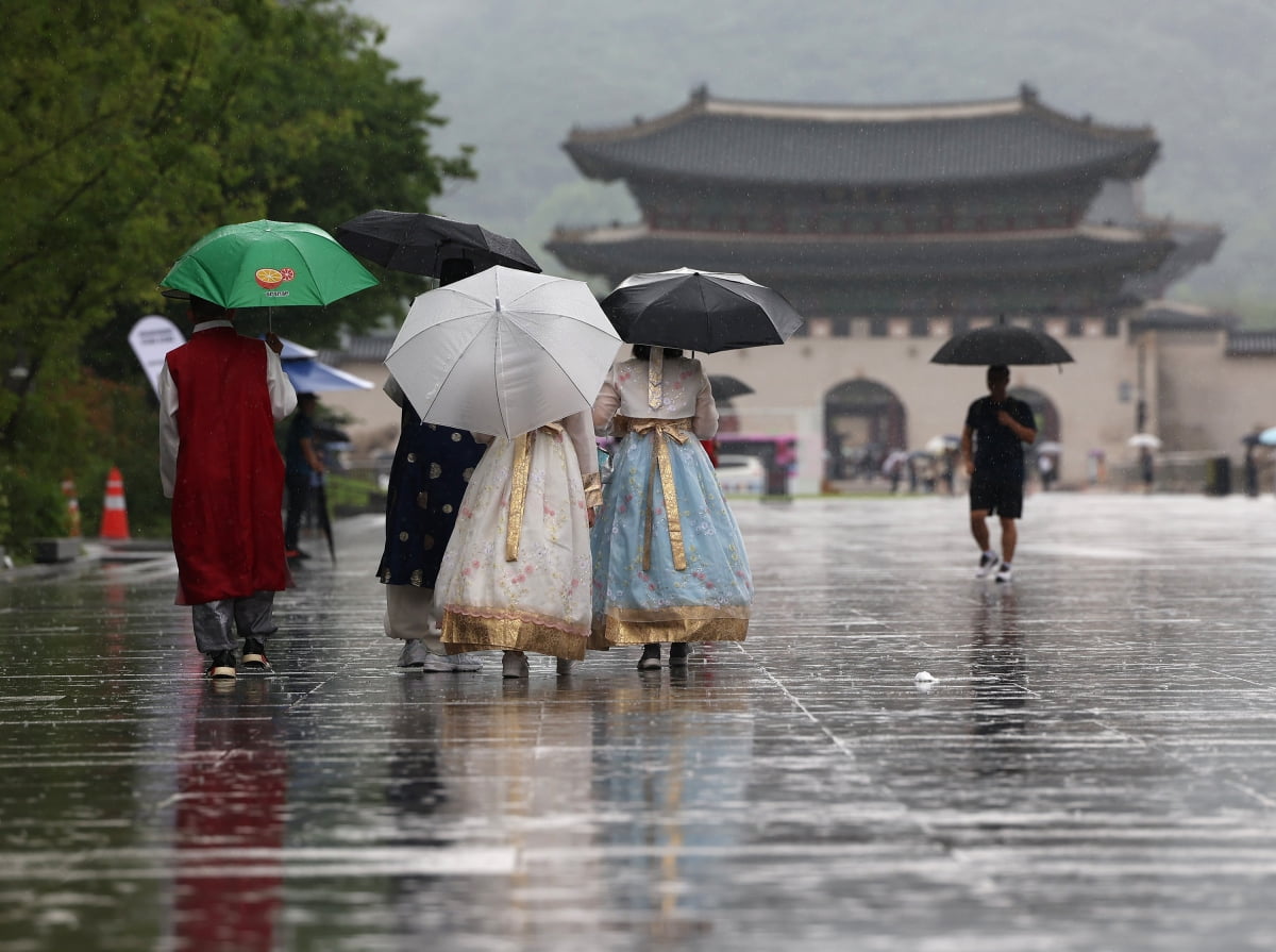장맛비가 내린 8일 오후 서울 광화문광장을 찾은 외국인들이 우산을 쓴 채 이동하고 있다. 사진=연합뉴스