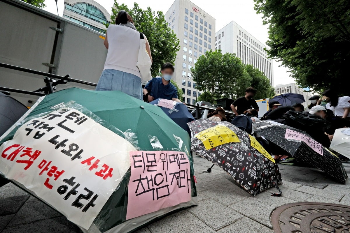 티몬과 위메프의 정산·환불 지연 사태가 지속되고 있는 28일 오후 서울 강남구 큐텐 본사 앞에서 피해자들이 사태 해결을 촉구하는 문구를 우산에 붙이며 시위를 준비하고 있다. 사진=뉴스1