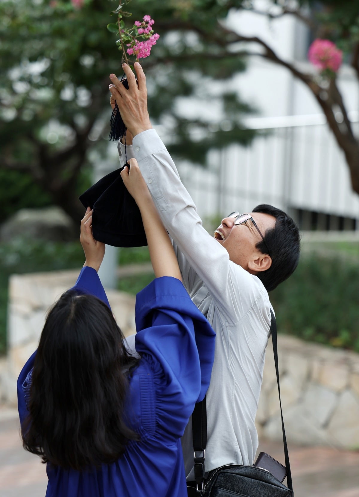 23일 서울 용산구 숙명여자대학교에서 열린 2023학년도 후기 학위수여식에서 한 졸업생과 부모가 기념 촬영을 하다 나무에 걸린 학사모를 빼내고 있다. /이솔 기자