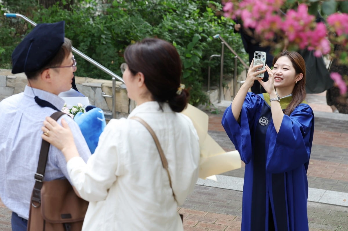 23일 서울 용산구 숙명여자대학교에서 열린 2023학년도 후기 학위수여식에서 한 졸업생이 학사모를 쓴 부모님의 사진을 찍어주고 있다. /이솔 기자