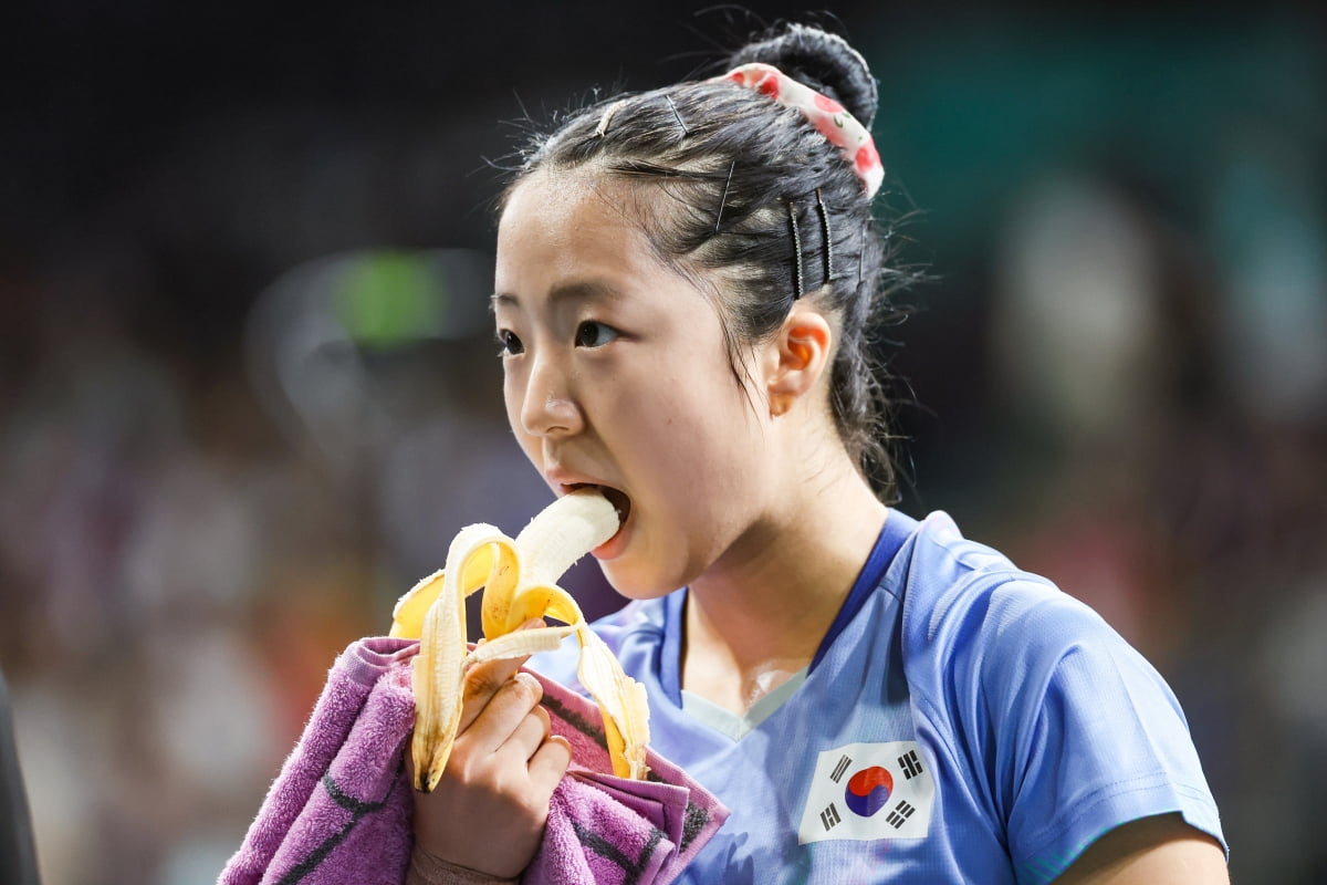 신유빈이 지난 2일(현지시간) 프랑스 파리 사우스 파리 아레나에서 열린 2024 파리올림픽 탁구 여자 단식 4강 중국 천멍과의 경기에 앞서 바나나를 먹고 있다. / 사진=연합뉴스