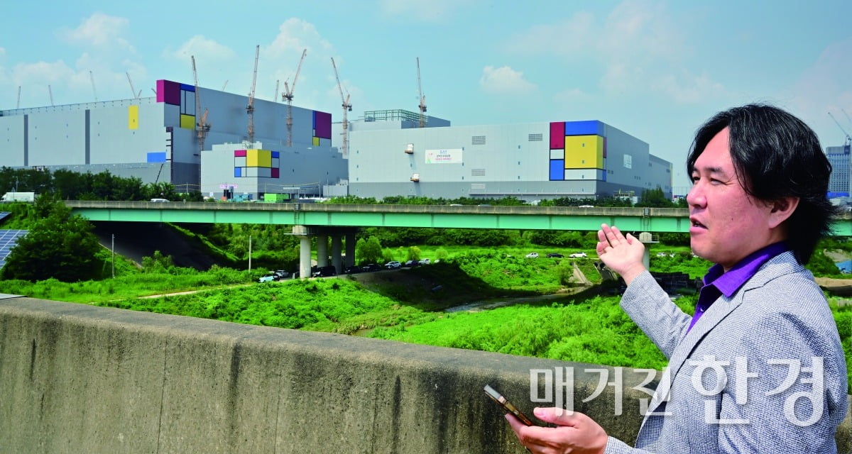 김시덕 작가가 삼성전자 평택 캠퍼스를 배경으로 설명하고 있다.