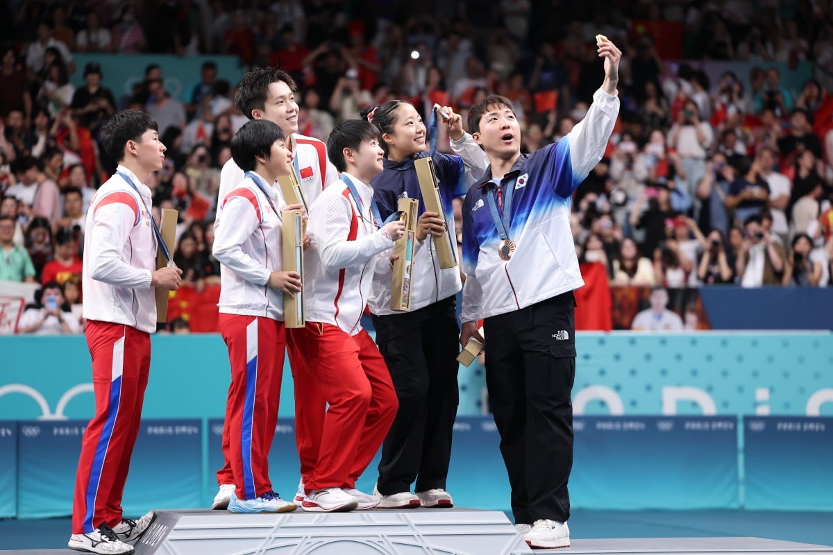 동메달을 딴 임종훈(오른쪽부터), 신유빈이 7월 30일(현지시간) 프랑스 파리 사우스 파리 아레나4에서 열린 2024 파리올림픽 탁구 혼합복식 시상식에서 금메달의 중국 쑨잉사, 왕추진, 은메달의 북한 김금용, 리정식과 삼성폰으로 셀카를 찍고 있다.  /사진=연합뉴스