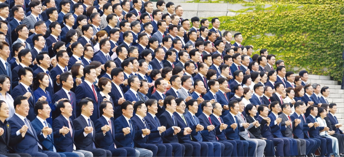 < 與野 맞잡은 손 놓지 않았으면… > 정기국회 개회식 겸 22대 국회 개원식이 열린 2일 우원식 국회의장과 국회의원들이 국회 본관 앞 계단에서 손을 맞잡고 기념사진을 찍고 있다. 22대 국회는 ‘87년 체제’ 이후 가장 늦게 개원식을 열어 ‘최장 지각’이라는 오명을 얻었다. 윤석열 대통령도 개원식에 불참했다.   뉴스1 