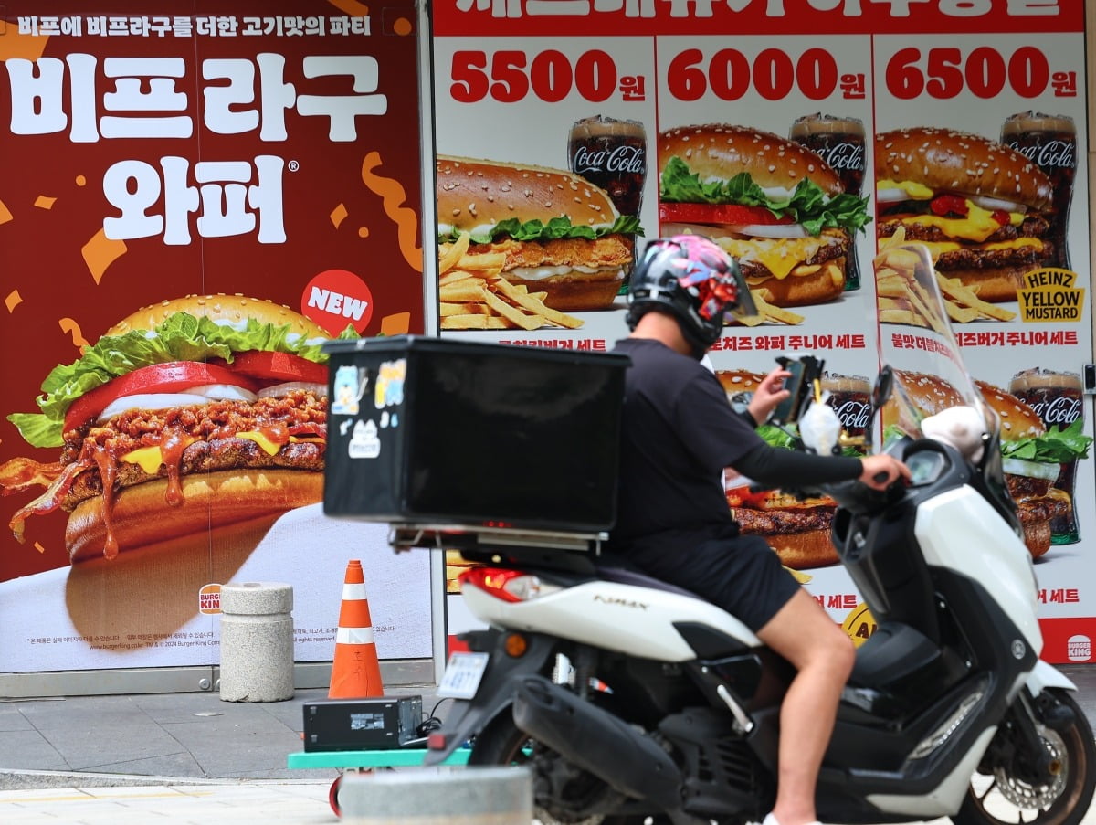  서울 시내의 한 패스트푸드 매장 앞에서 배달기사가 핸드폰을 확인하고 있다. 사진=연합뉴스