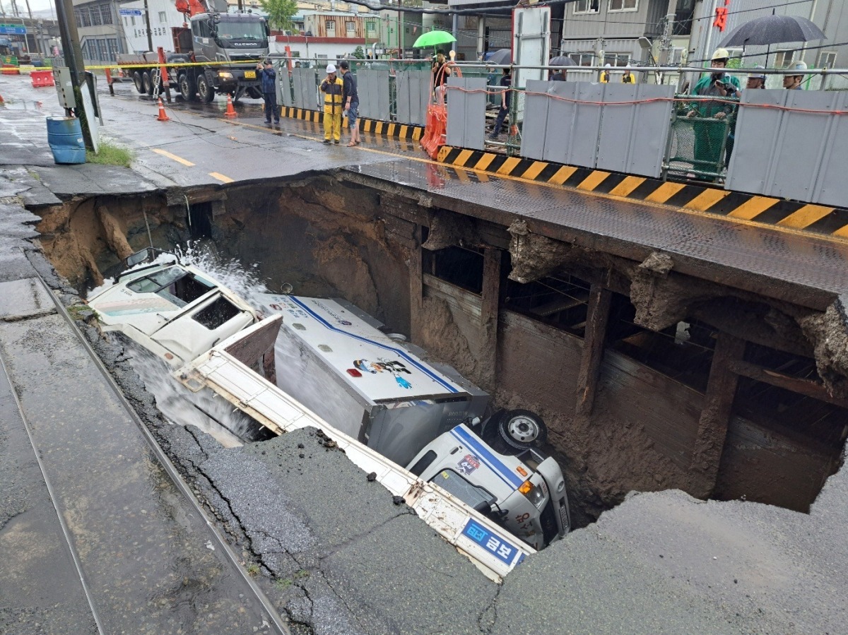 21일 오전 8시45분께 부산 사상구 한 도로에서 가로 10m, 세로 5m, 깊이 8m 가량의 대형 땅꺼짐 현상(싱크홀)이 발생해 도로에서 배수 지원을 하던 삼락119안전센터 배수 차량과 5톤 트럭이 빠져있다. 사진=뉴스1