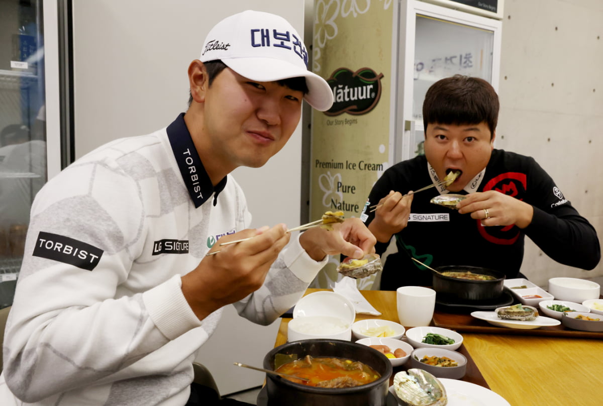 최경주가 선물한 전복을 즐기고 있는 고군택(왼쪽)과 함정우. 지애드 제공