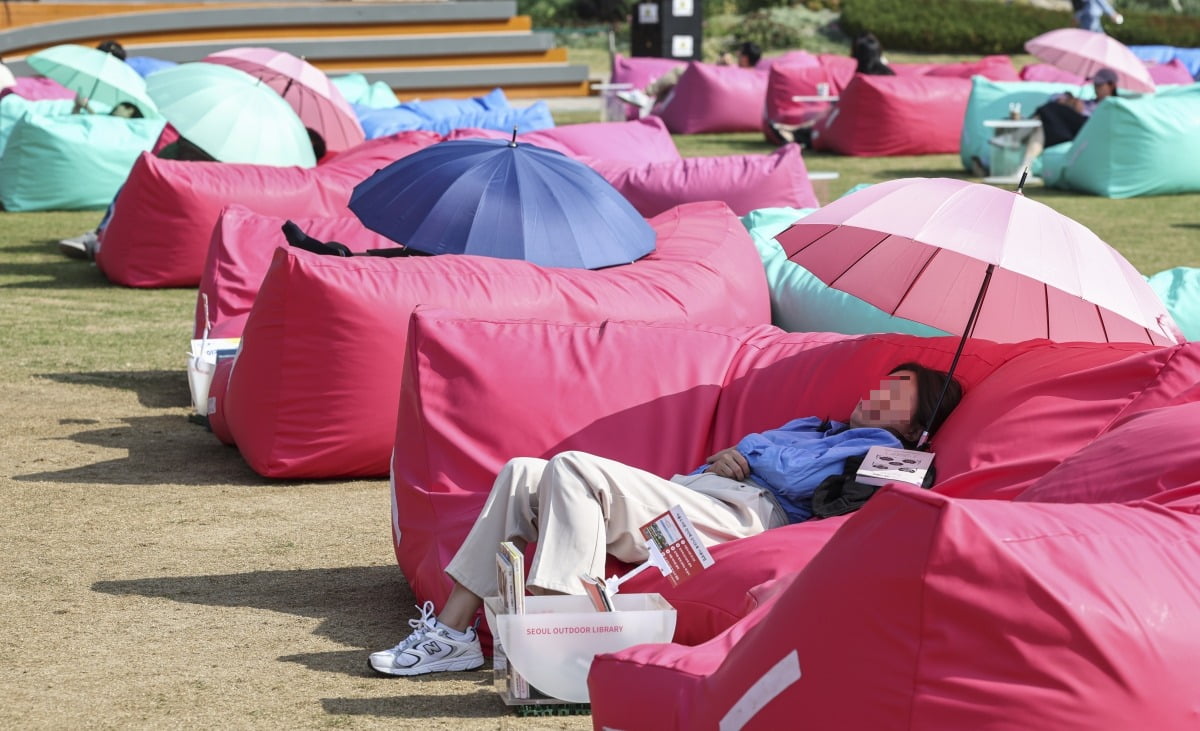 17일 오후 서울 중구 서울광장에서 시민들이 책을 읽다 낮잠을 자고 있다.