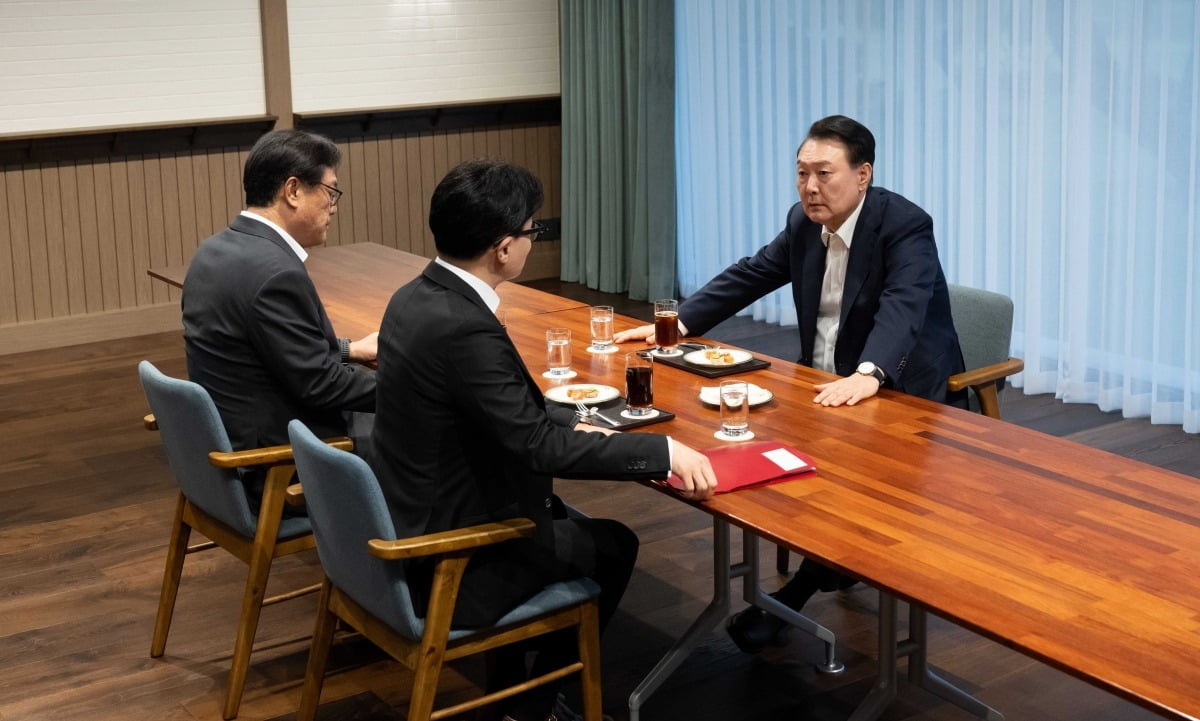 윤석열 대통령이 21일 용산 대통령실 앞 파인그라스에서 한동훈 국민의힘 대표와 차담을 하고 있다. 이날 윤 대통령과 한 대표는 직사각형 테이블을 사이에 두고 마주 앉았고, 한 대표 왼쪽에는 정진석 대통령실 비서실장이 자리했다./대통령실 제공