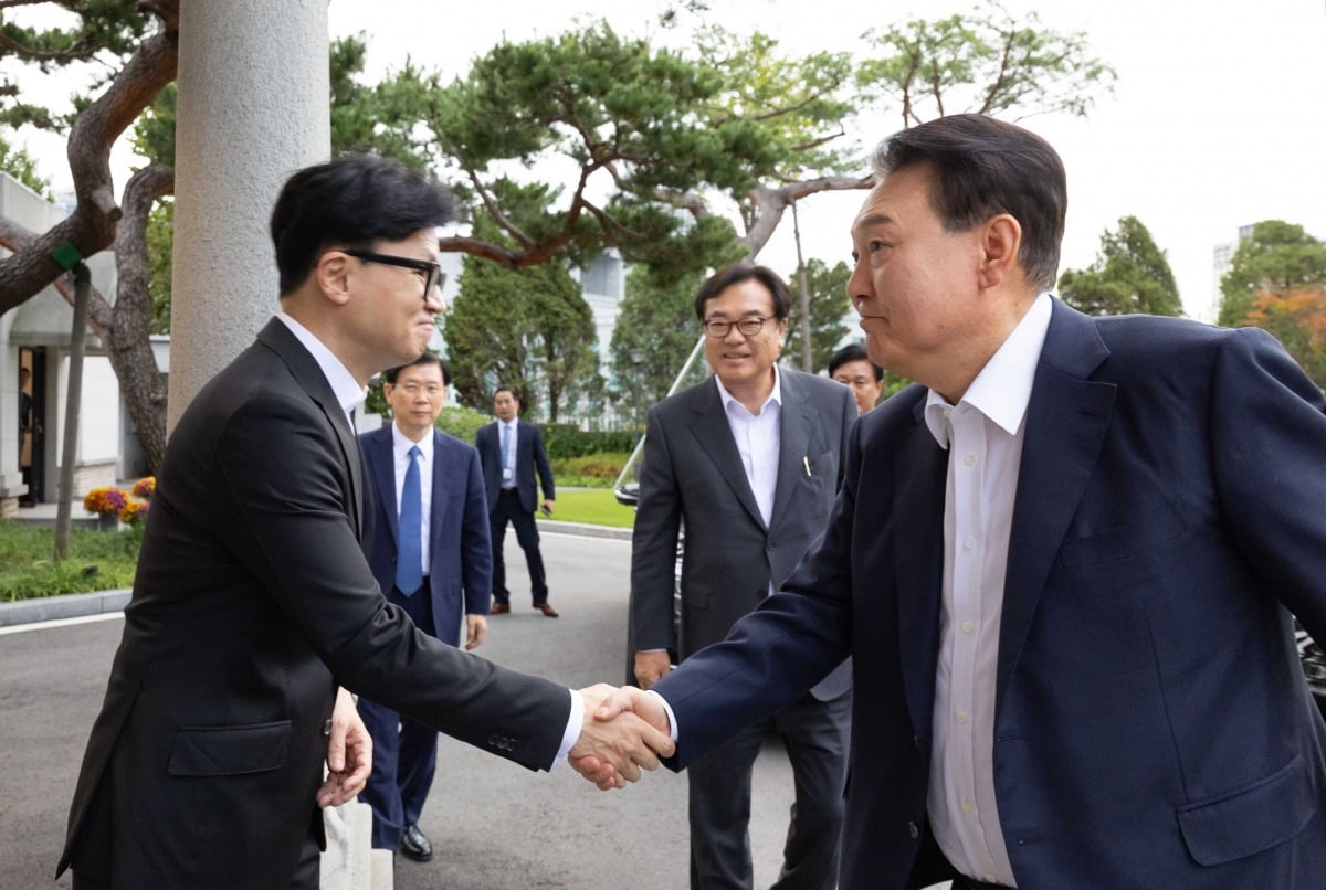 윤석열 대통령과 한동훈 국민의힘 대표가 21일 면담에 앞서 용산 대통령실 앞 파인그라스에서 악수하고 있다./대통령실 제공