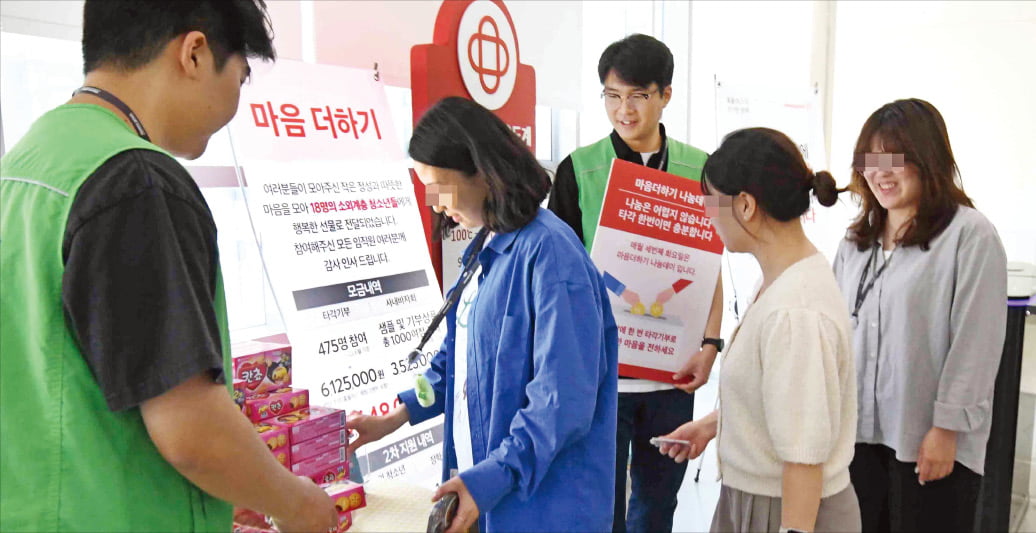 홈플러스 임직원들이 단말기에 사원증을 대서 기부하는 ‘타각 기부 캠페인’에 참여하고 있다.  홈플러스 제공 