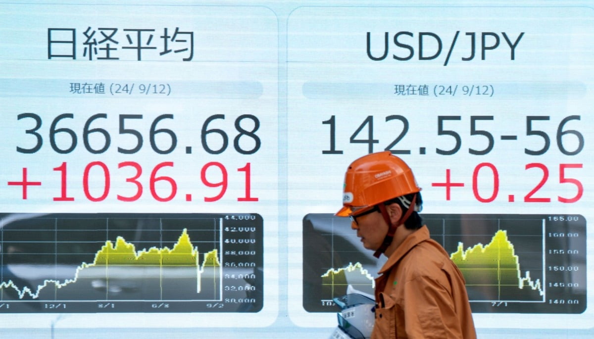 지난 9월 12일 일본 도쿄 시내에서 니케이 지수가 표시된 전광판 앞으로 걸어가는 시민. 사진=연합AFP