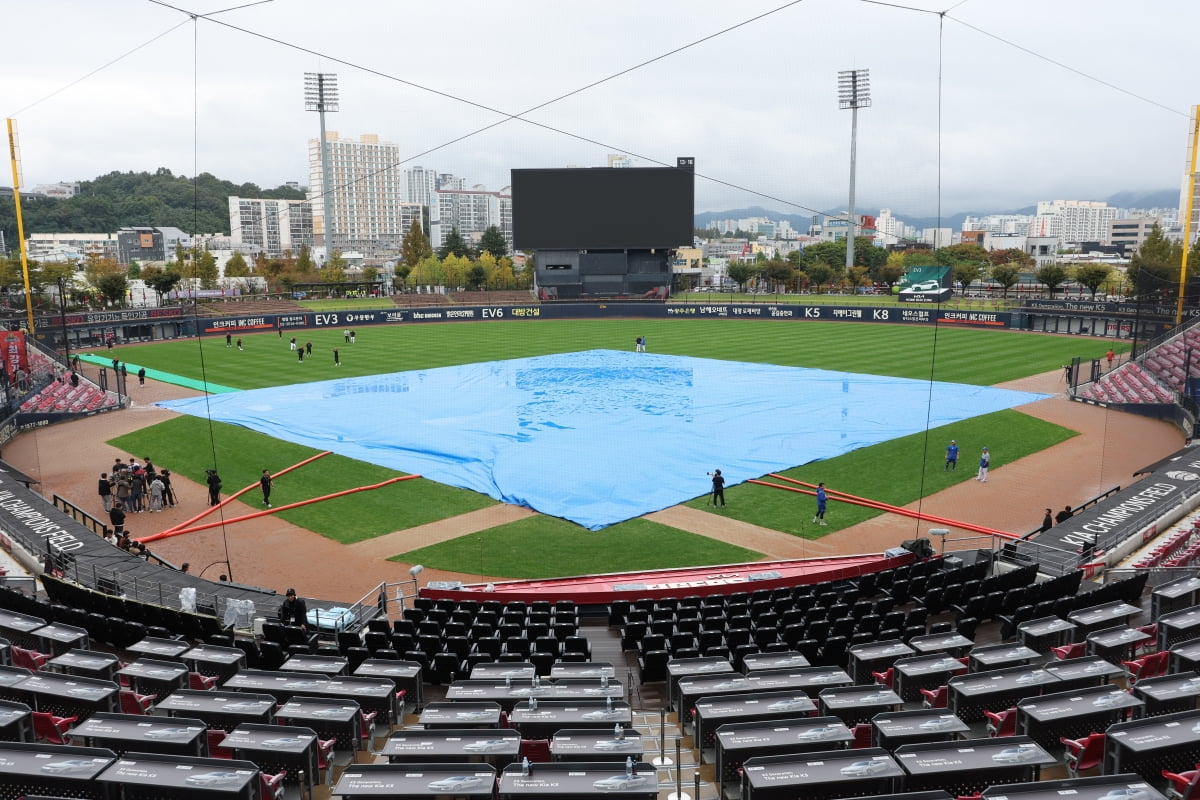 전날 우천으로 중단됐다 재개를 앞둔 2024 신한 SOL뱅크 KBO 포스트시즌 한국시리즈 1차전과 2차전 경기가 예정된 광주 기아챔피언스필드에 우천에 대비해 대형 방수포가 덮여 있다. 사진=연합뉴스