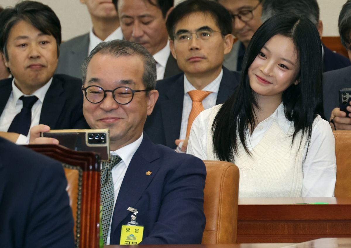 지난 15일 국회 환경노동위원회 국정감사에 출석한 정인섭 한화오션 거제사업장 사장이 뒤에 앉은 뉴진스 하니와 셀카를 찍는 모습. / 사진=뉴스1