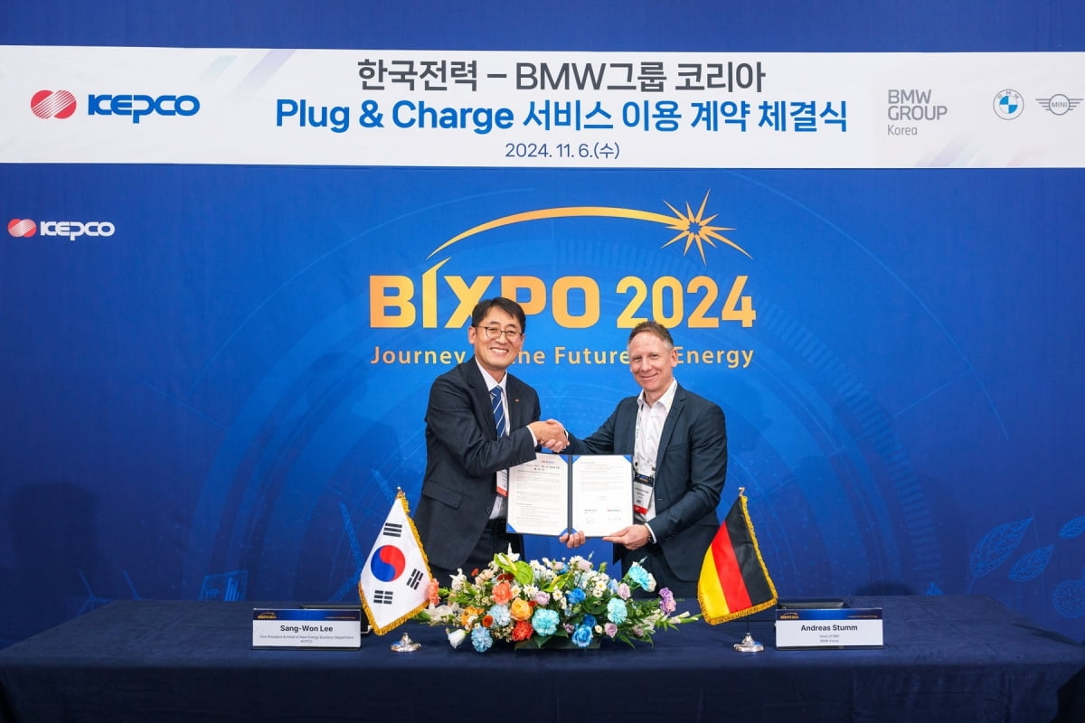 안드레아스 스툼 BMW 그룹 R&D 센터 코리아 총괄(오른쪽)과 이상원 한국전력 에너지신사업처장(왼쪽)이 PnC 충전 서비스 이용 계약 체결식에서 기념촬영을 하고 있다./사진=BMW그룹코리아