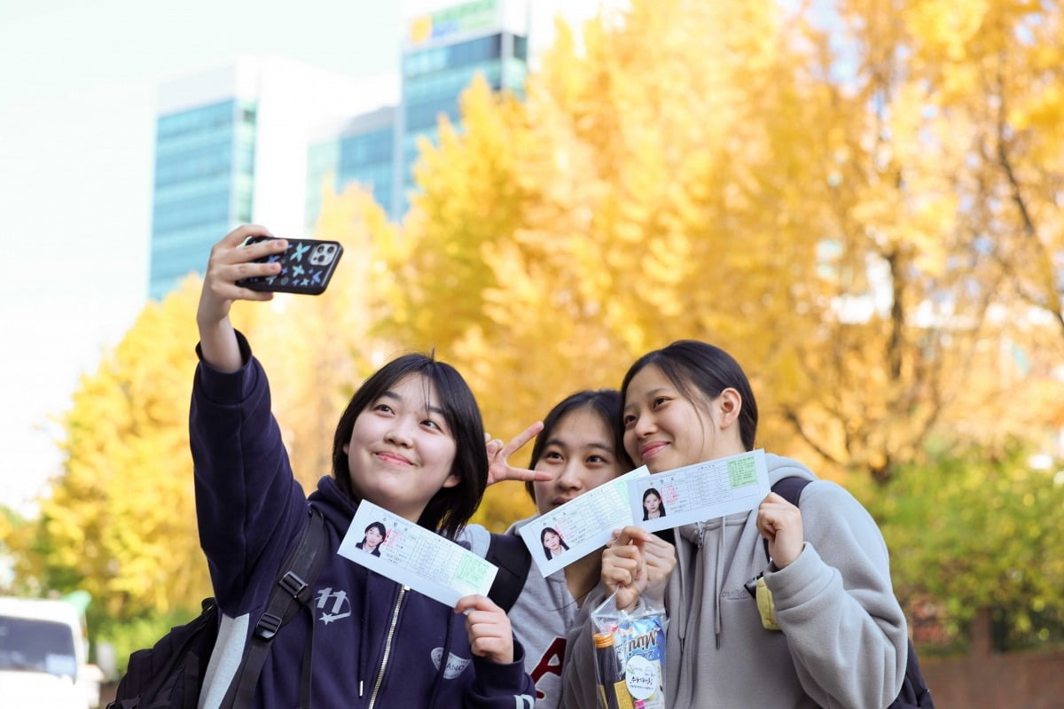 2025학년도 대학수학능력시험 예비소집일인 13일 서울 이화여자외고 앞에서 수험생들이 수험표를 들고 미소 짓고 있다./최혁 기자 