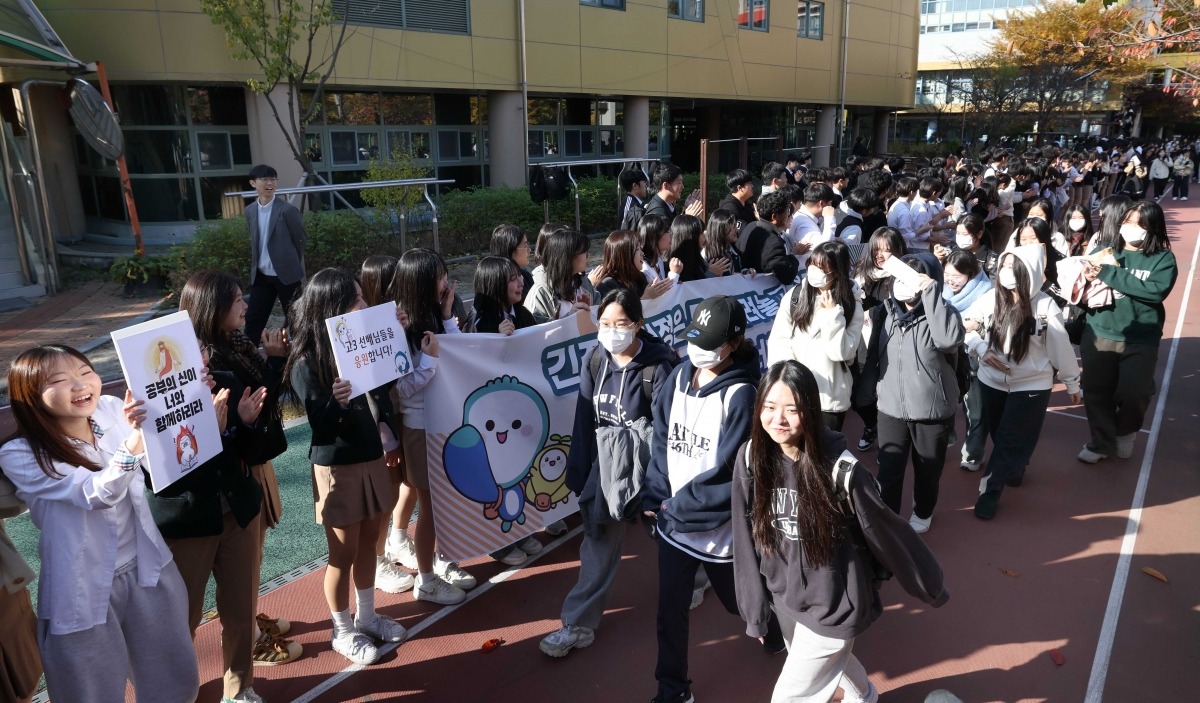 13일 서울 성수고등학교에서 수험생들이 후배들의 응원을 받으며 교정을 나서고 있다./김범준 기자