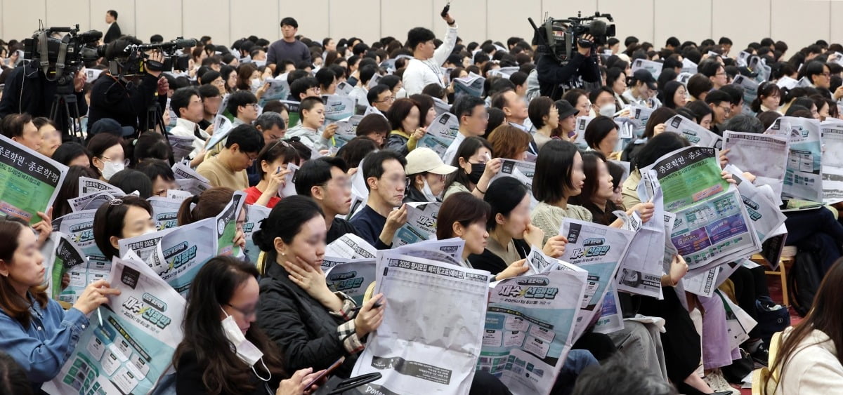 15일 서울 세종대학교에서 열린 종로학원 2025 정시 합격점수 예측 및 전략 설명회에서 학부모들이 정시모집 배치 참고표를 보며 설명을 듣고 있다./최혁 기자