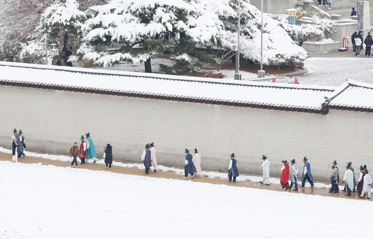 서울과 수도권에 폭설이 내린 27일 서울 종로구 경복궁 담벼락을 따라 한복을 차려 입은 관광객들이 발걸음을 옮기고 있다. /이솔 기자