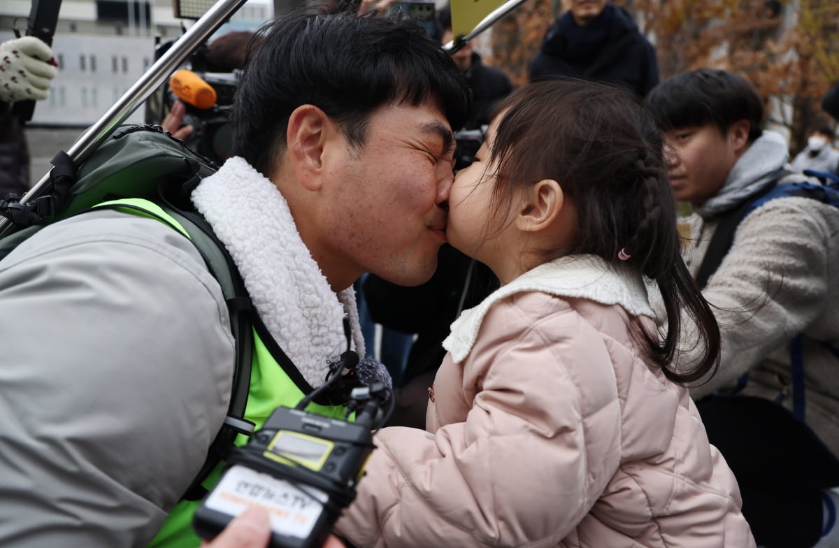 국내에는 치료법이 없는 희귀병을 앓고 있는 네 살 딸 사랑이의 치료비용을 위해 전국 곳곳을 돌며 후원을 요청하고 있는 전요셉 씨가 29일 오후 최종 목적지인 서울 광화문광장에 도착, 마중 나온 사랑이와 뽀뽀를 하고 있다. /사진=연합뉴스