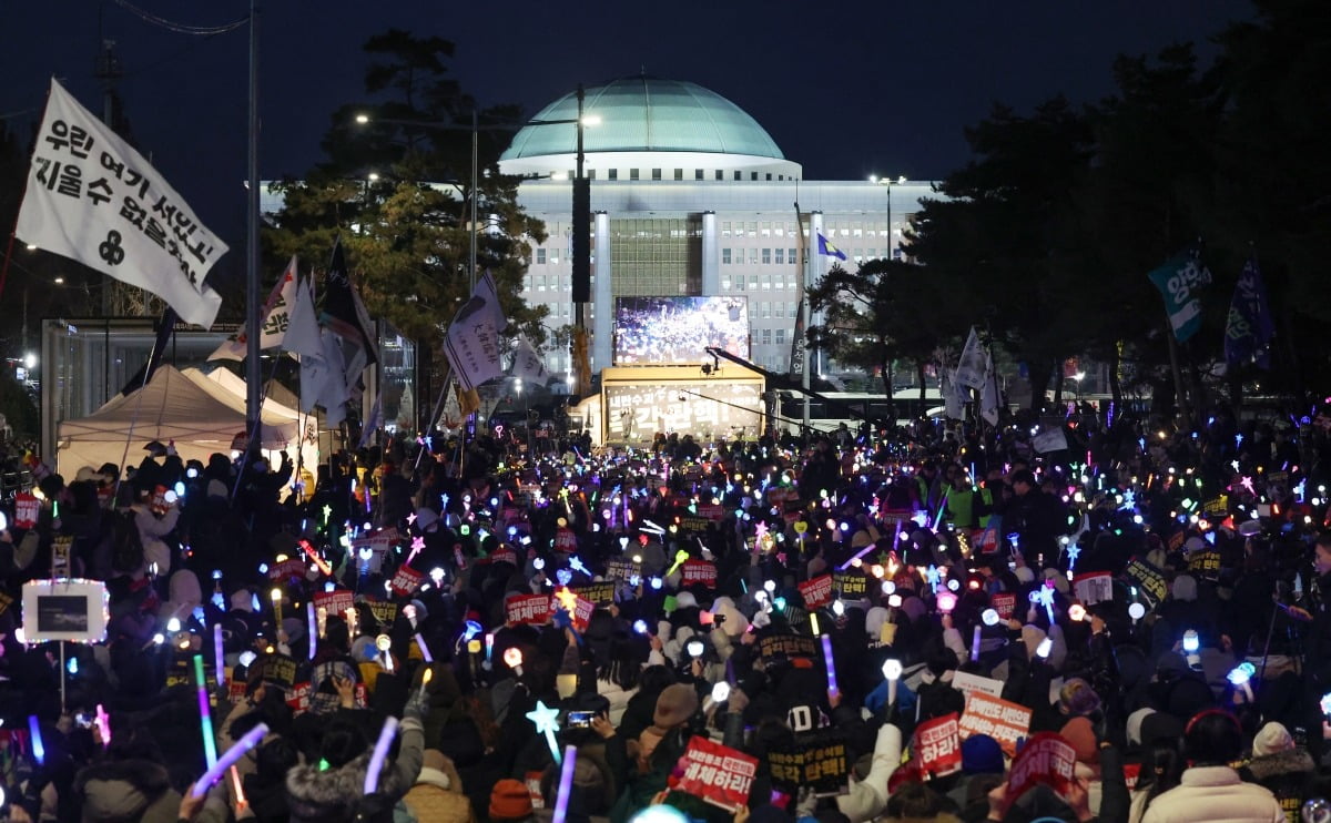 윤석열 대통령에 대한 두 번째 탄핵소추안 표결을 하루 앞둔 13일 국회의사당 앞에서 시민들이 피켓과 응원봉을 들고 탄핵을 촉구하는 시위를 벌이고 있다./ 최혁 기자