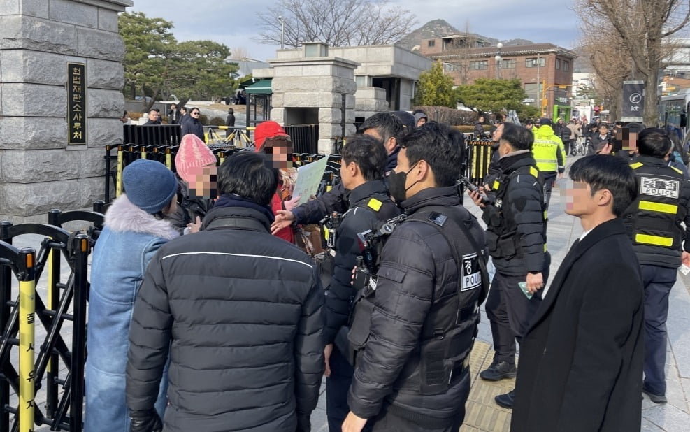 16일 헌재 앞에서 경찰이 '탄핵 반대'를 촉구하는 시민들에게 집회 시위 관련 규정을 따라줄 것을 요청하고 있다. 민경진 기자