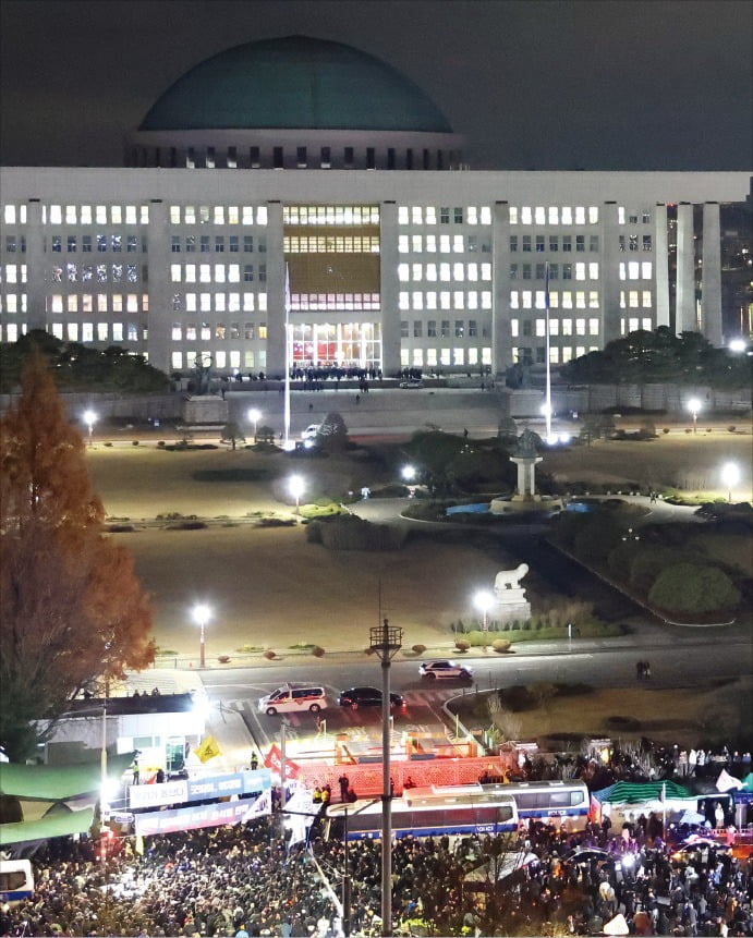 < 혼돈의 국회 > 윤석열 대통령이 비상계엄을 선포한 4일 새벽 서울 여의도 국회의사당에 계엄령 선포에 반대하는 시민과 이를 저지하는 경찰이 모여 혼잡스러운 상황을 빚고 있다.  연합뉴스 