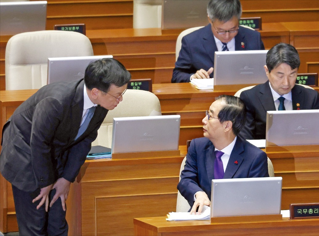 < 대통령직 승계 서열 1, 2위 > 한덕수 국무총리(오른쪽)가 13일 국회 본회의장에서 열린 긴급 현안질문에 참석해 최상목 부총리 겸 기획재정부 장관과 대화하고 있다. 한 총리는 이날 ‘12·3 비상계엄 선포’가 국무회의에서 자신을 거치지 않았으며 “사전에 전혀 알지 못했다”고 밝혔다.  연합뉴스 