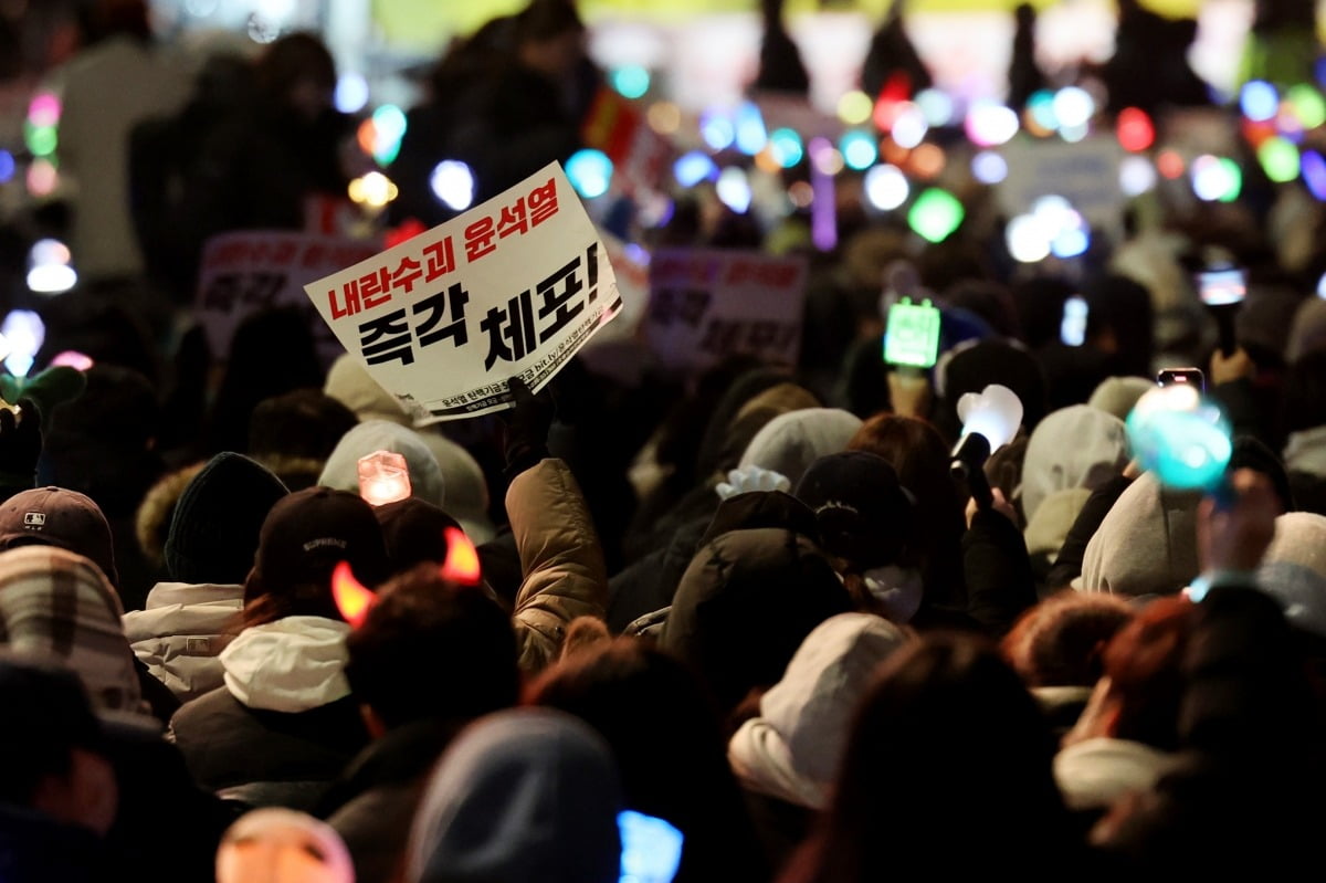 8일 오후 서울 여의도 국회 앞에서 열린 윤석열 탄핵 및 구속을 촉구하는 촛불문화제에서 참가자들이 관련 손팻말과 응원봉을 들고 있다./사진=연합뉴스