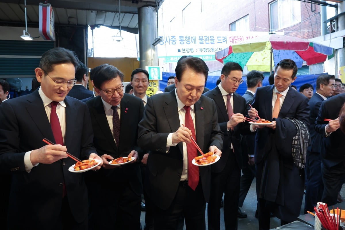 윤석열 대통령이 지난해 12월 6일 부산 중구 깡통시장을 방문해 기업인들과 함께 떡볶이를 시식하고 있다. 왼쪽부터 이재용 삼성전자 회장, 박형준 부산시장, 윤 대통령, 구광모 LG그룹 회장, 김동관 한화그룹 부회장. / 사진=대통령실 제공