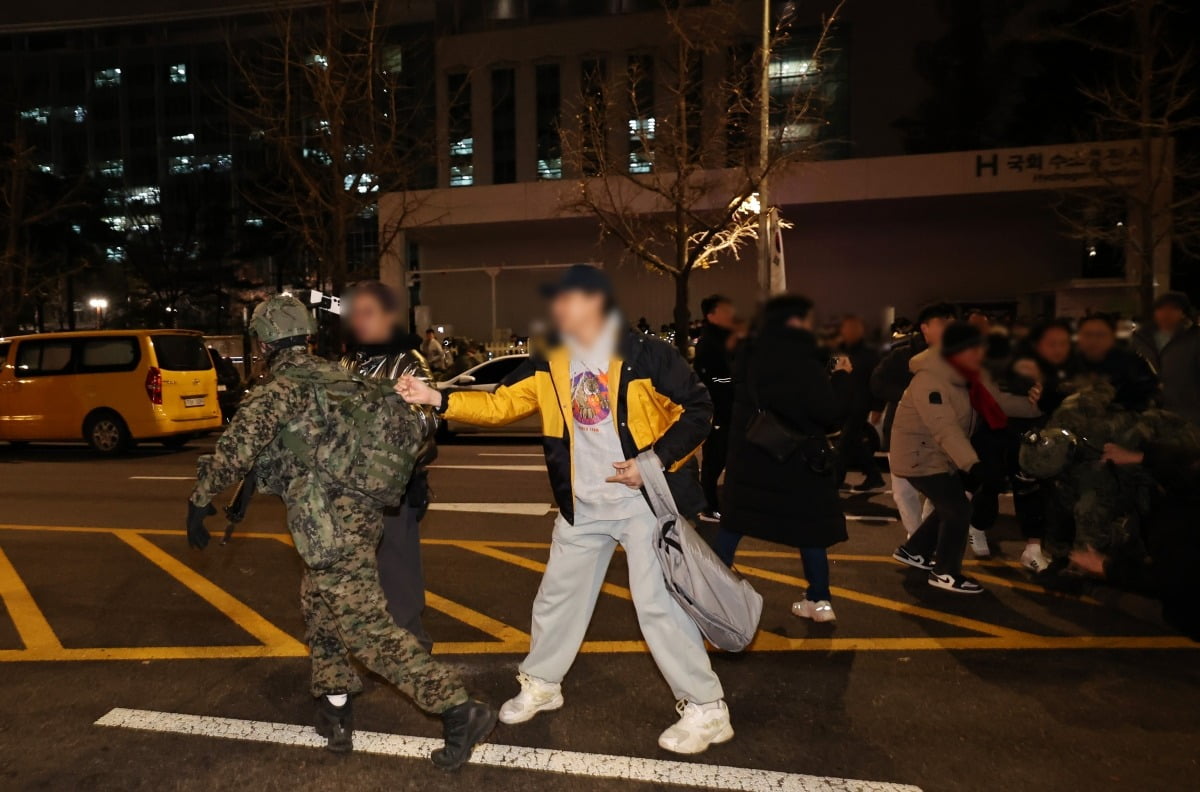 윤석열 대통령이 비상계엄령을 전격 선포한 4일 새벽 서울 여의도 국회 앞에서 시민들이 경내로 진입하려는 계엄군을 붙잡아 막아서고 있다. 사진=뉴스1