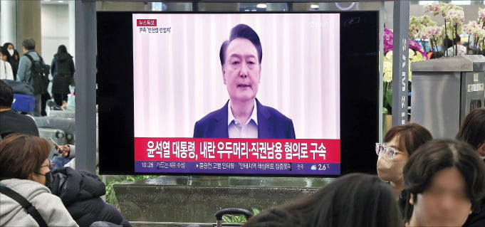 윤석열 대통령이 구속된 19일 시민들이 인천국제공항 제1터미널 입국장에서 관련 속보를 지켜보고 있다.  뉴스1 