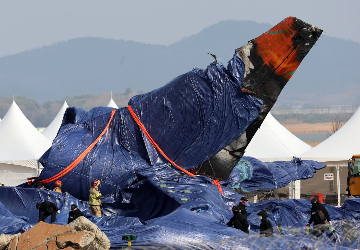 지난 6일 오후 전남 무안공항 사고 현장에서 소방ㆍ경찰특공대원들이 강풍에 방수포가 날리지 않게 보강 작업하고 있다./ 사진=연합카지노 슬롯 머신 하는 법