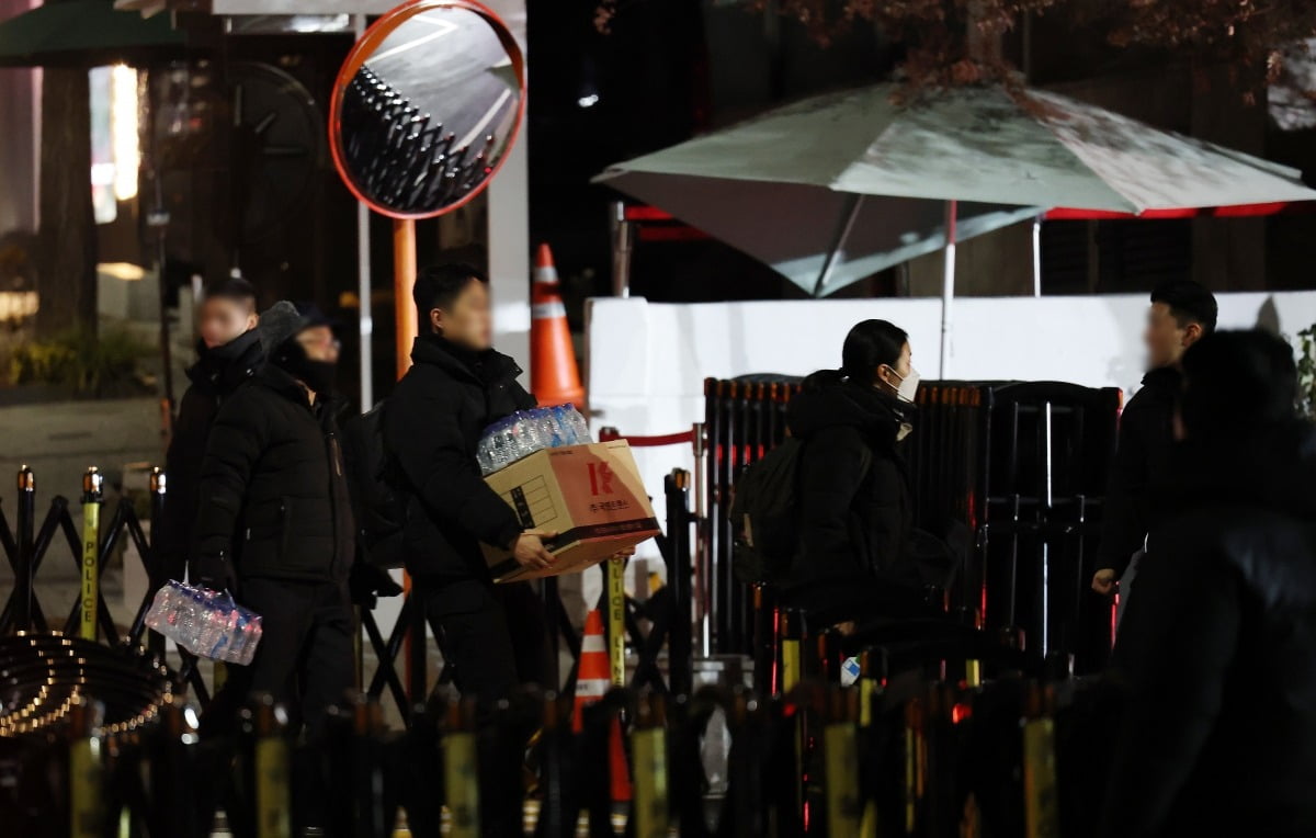 4일 오전 서울 용산구 대통령 관저 앞에서 관계자들이 물과 박스 등을 갖고 관저로 들어가고 있다./사진=뉴스1