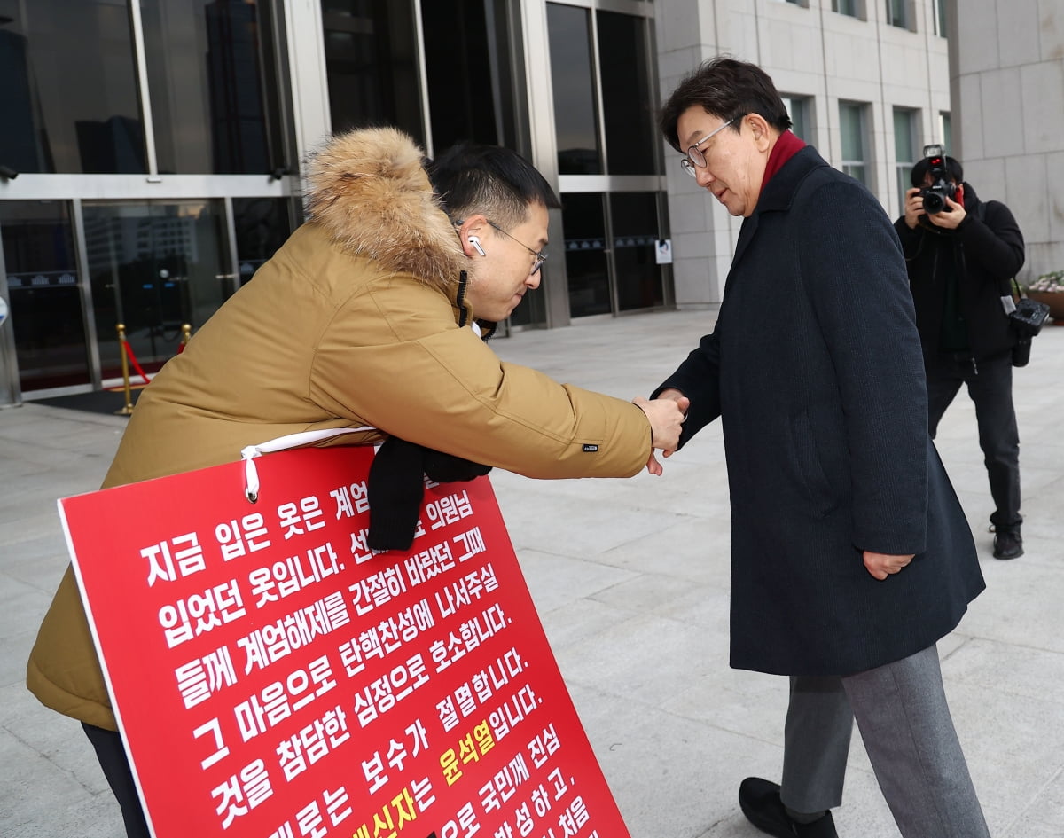 2024년 12월 13일 국민의힘 권성동 원내대표가 국회 본청 앞에서 탄핵 바카라 사이트을 호소하는 김상욱 의원과 악수하고 있다. / 사진=연합뉴스