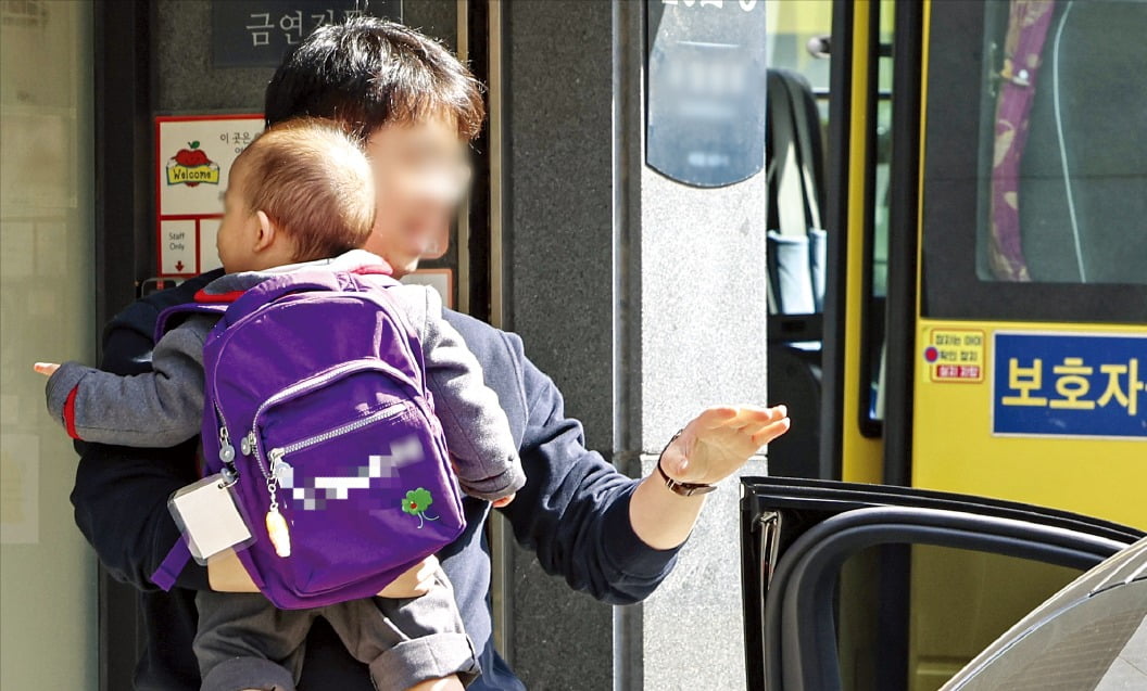 서울 시내 한 영어학원에서 학부모가 아기를 안고 하원하고 있다. /사진=임형택 기자