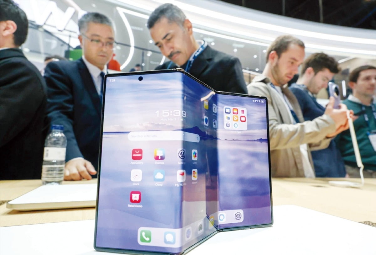 지난 3일 스페인 바르셀로나에서 열린 MWC 2025를 찾은 관람객들이 화웨이 부스에서 두 번 접는 폰인 메이트XT를 살펴보고 있다.   뉴스1
