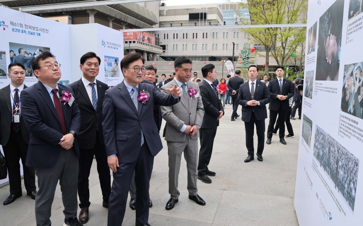 이호재 한국사진기자협회장, 우원식 국회의장 등 내빈들이 21일 서울 종로구 광화문 광장에서 열린 제61회 한국보도사진전 '순간의 포착, 진실의 기록' 개막식에서 작품을 관람하고 있다.
